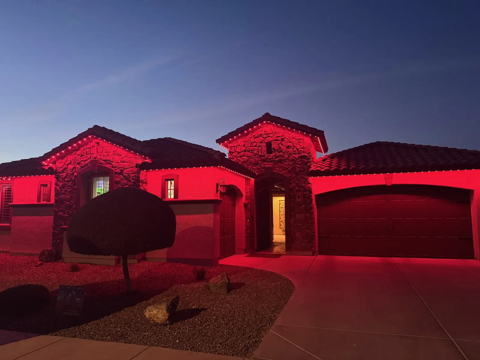 Stone front home lit entirely in red