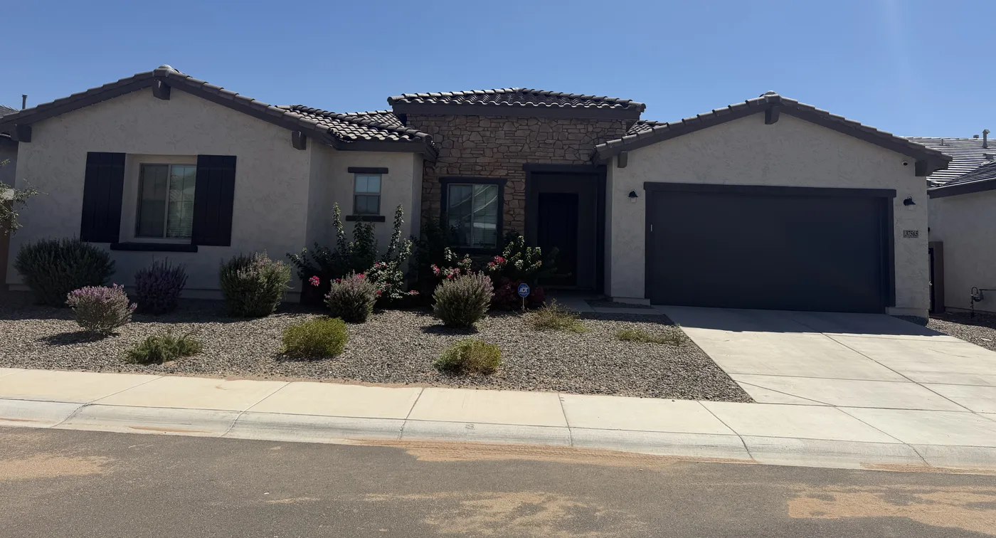 Single story stucco home in daylight with the permanent lighting track hidden under the roof edge