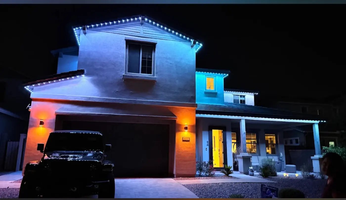 Home with multi color permanent lighting showing separate colors on each section of roofline