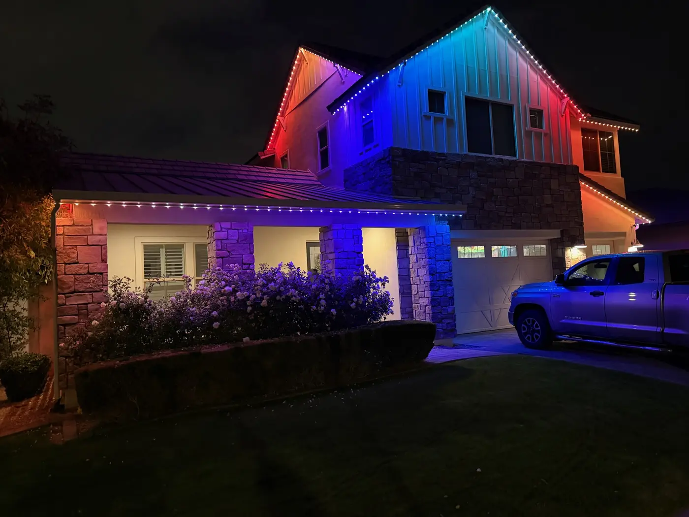 Home lit in red, white and blue permanent LED lighting across two rooflines
