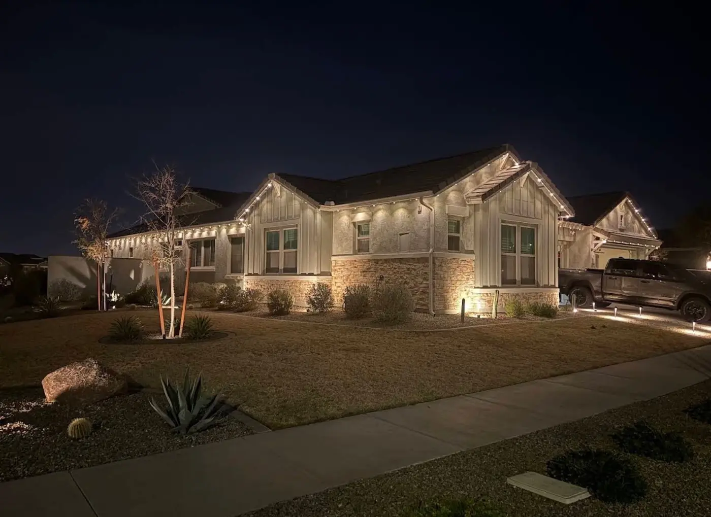 Single story ranch home with warm white permanent lighting along the full roofline